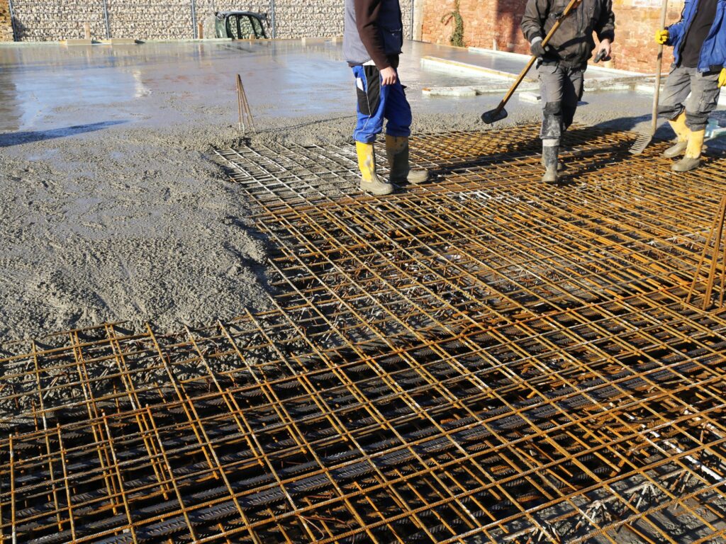 workers' foot stepping on a construction floor cement